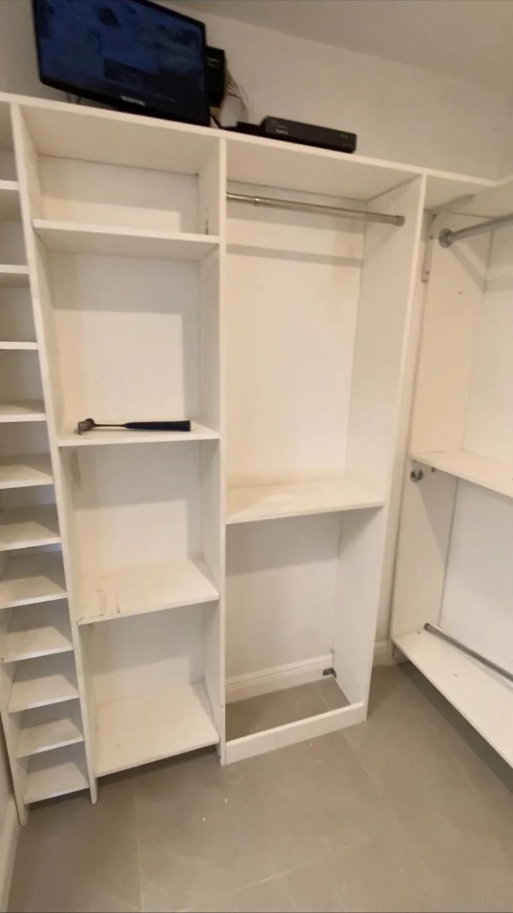 White closet shelving and hanging rods during installation