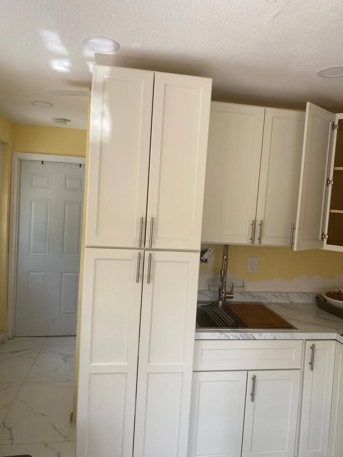 White kitchen cabinets and sink area during renovation