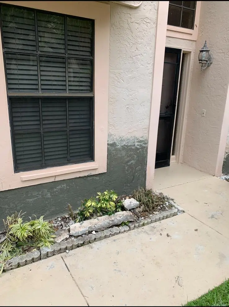 Fresh stucco base repair around an exterior entry column and window wall